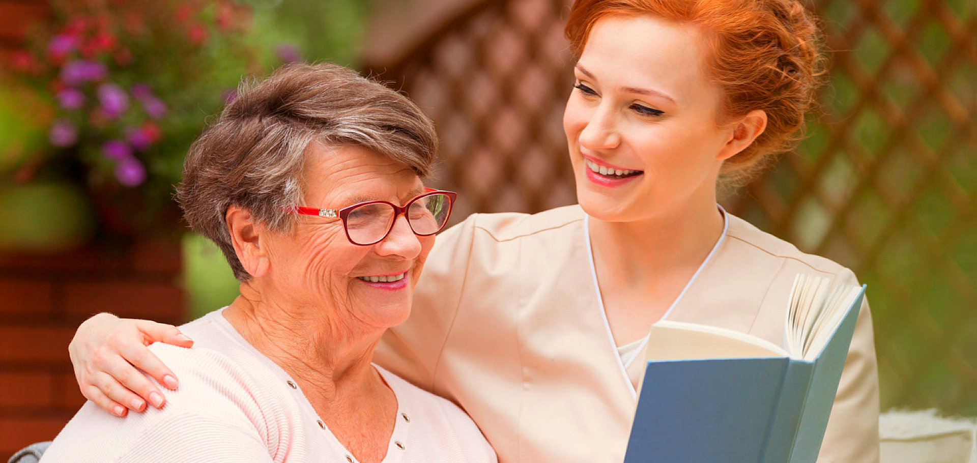 caregiver reading with a smiling senior woman